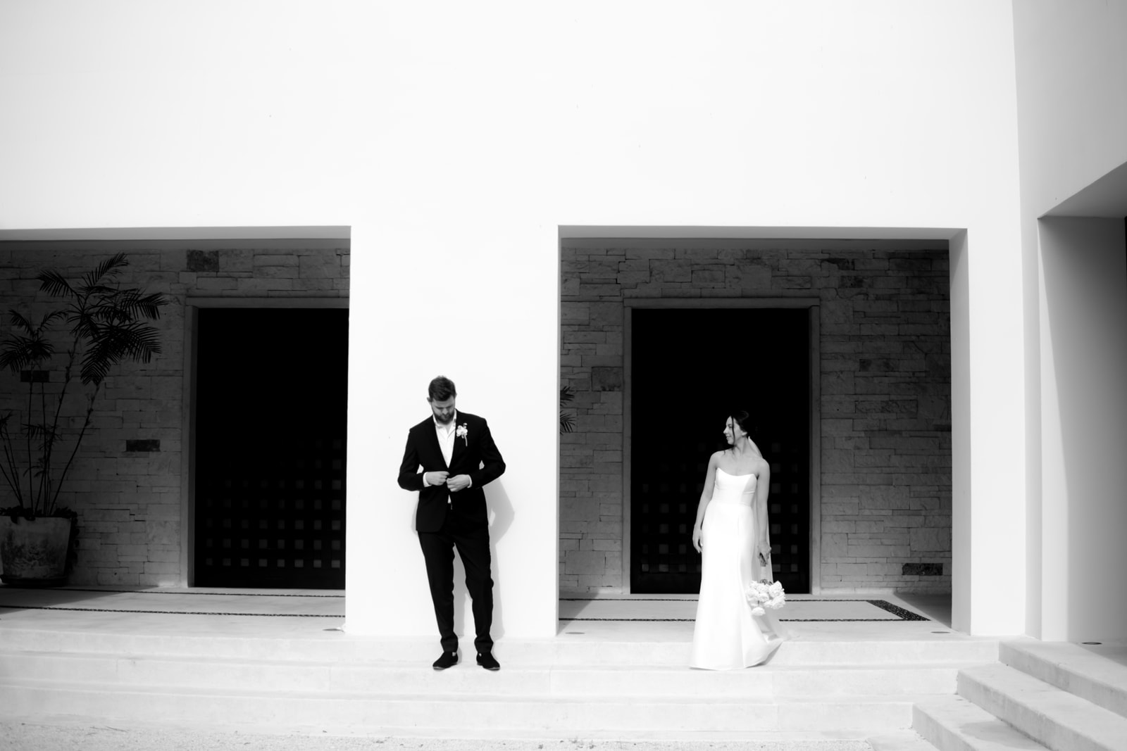 Bride and groom standing apart during a destination wedding portrait at a modern venue in Tulum Mexico