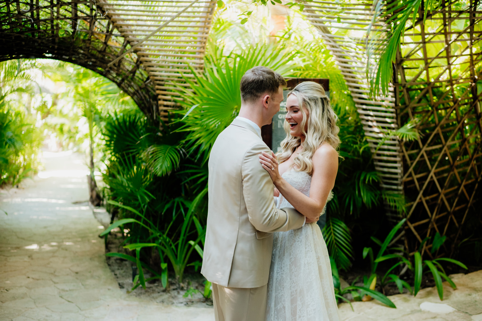 Bride and groom embracing during a destination wedding portrait in a tropical garden in Tulum Mexico